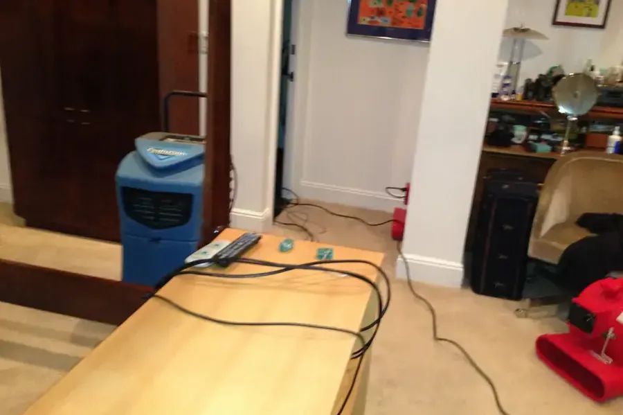Dehumidifier and air mover drying a water-damaged room